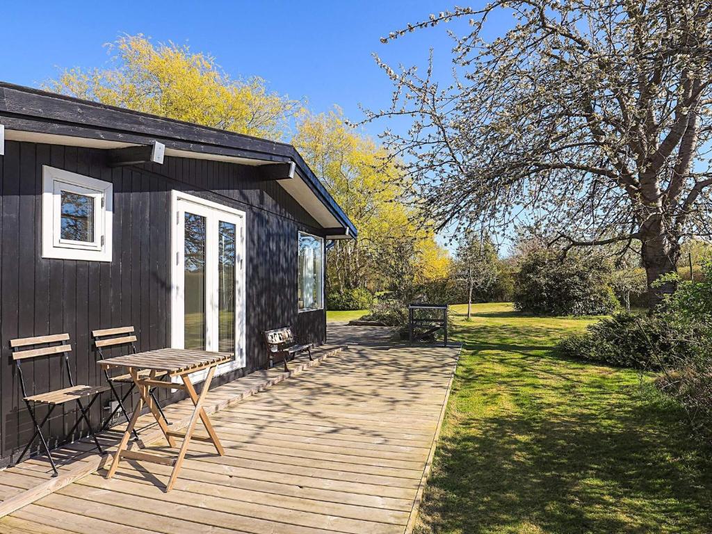 a cabin with a table and chairs on a deck at 4 star holiday home in Græsted in Græsted