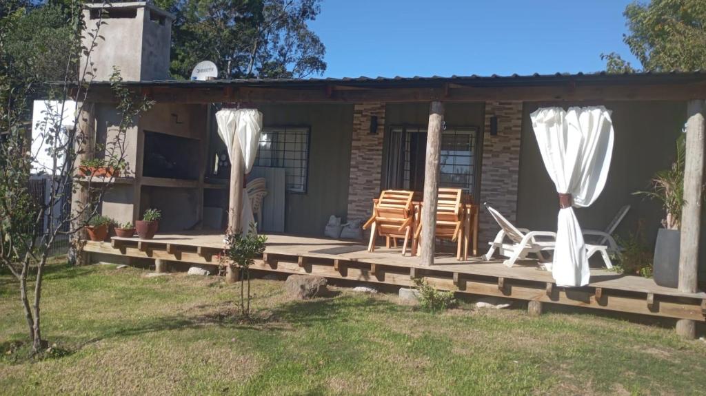 a house with a porch with chairs and curtains at Veraniega in Playa Hermosa
