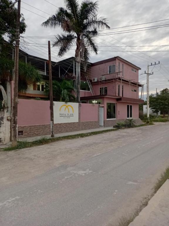 an empty street with a pink building and a palm tree at Portal de José - Hotel Boutique in Ciudad Valles