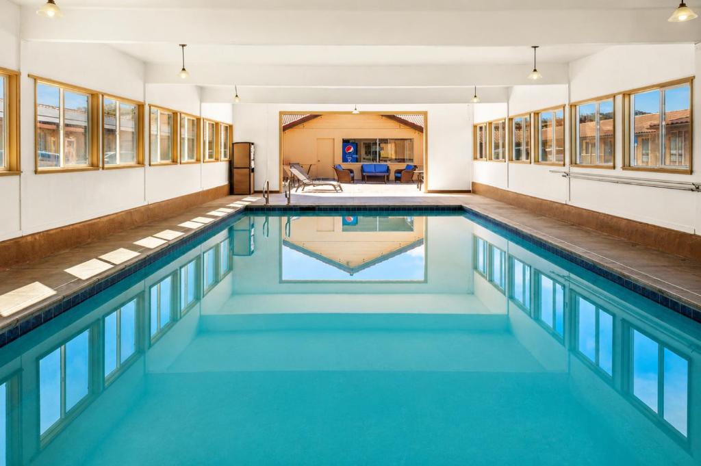 a swimming pool with blue water in a building at El Castell Motel in Monterey
