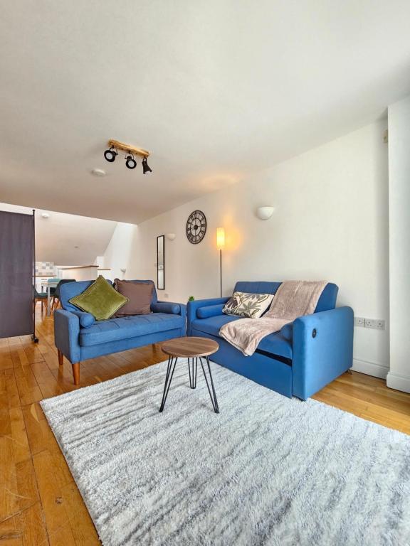 a living room with two blue couches and a table at Flat In City Centre in Cambridge