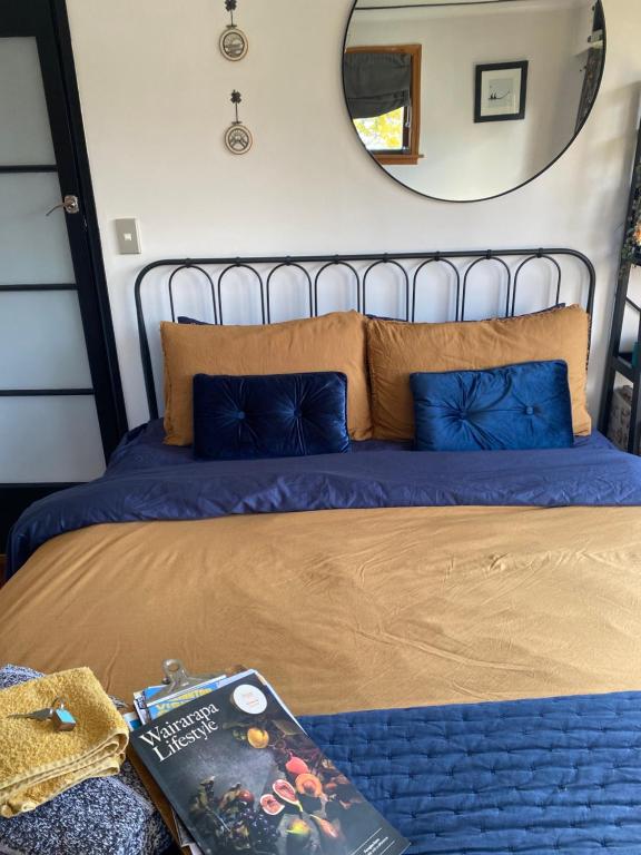 a bed with a mirror and a book on it at Right Side in Greytown