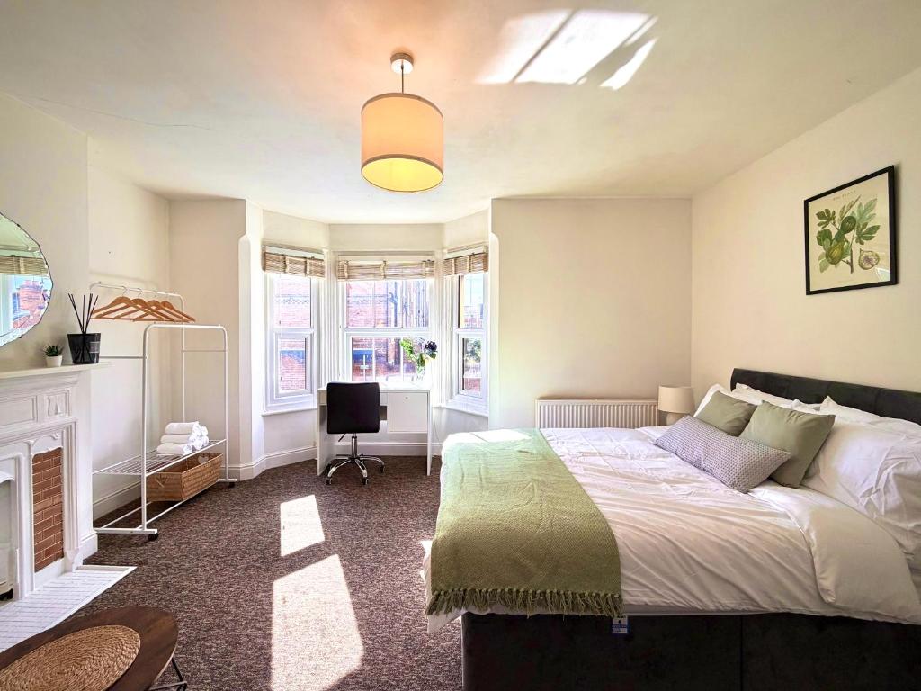 a bedroom with a bed and a desk in it at Central Reading Guest House in Reading