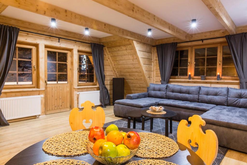 a living room with a couch and a table with fruit at Domek w górach in Kościelisko