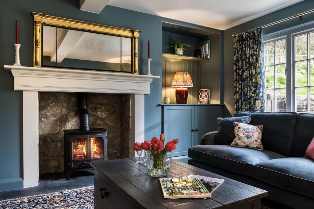 a living room with a fireplace and a couch at Roft Bank Cottage in Oswestry