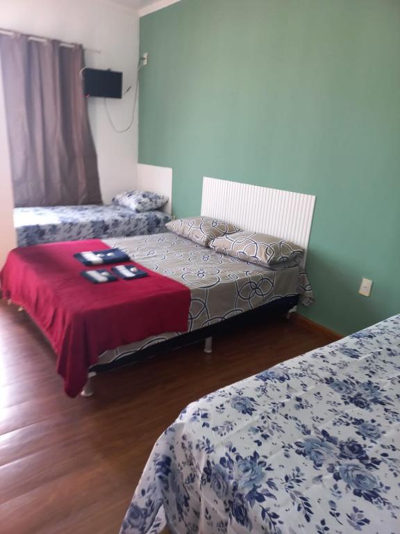 a room with two beds and a red blanket at Hotel Status in Jaguarão