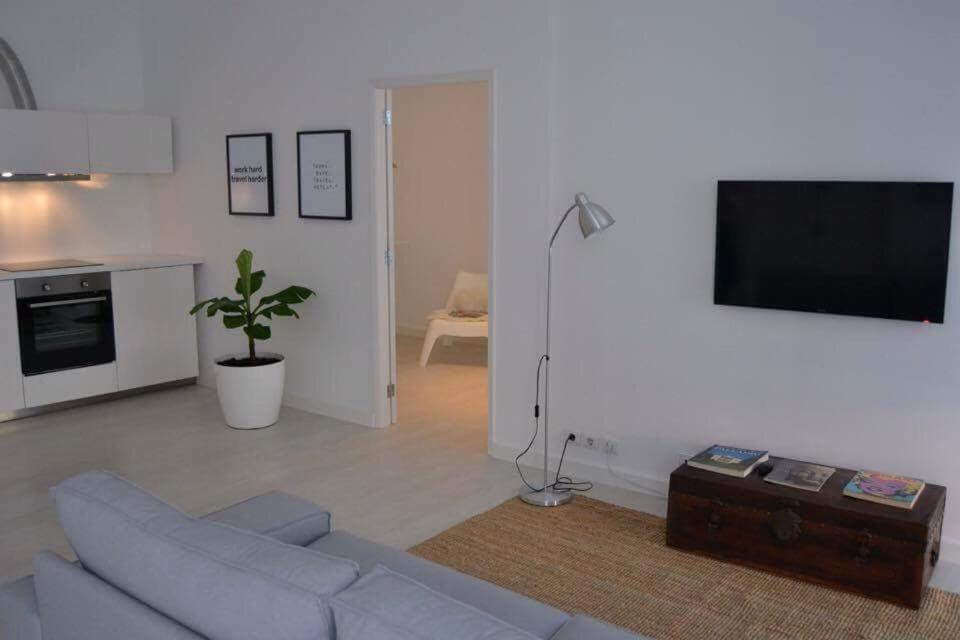 Il comprend un salon doté d'un canapé et d'une télévision à écran plat. dans l'établissement Charming Apartment 101, à Funchal