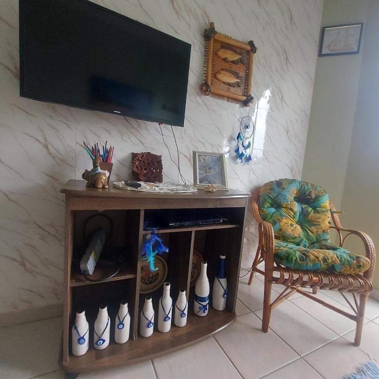 a desk with a chair and a television on a wall at Gourmet space in São Paulo