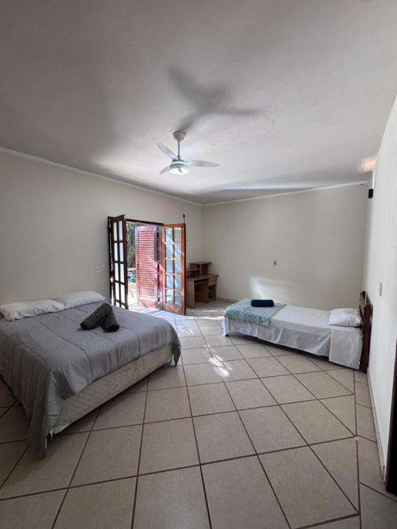 a bedroom with two beds and a ceiling fan at Quarto suíte privativo em campinas para 4 pessoas in Campinas
