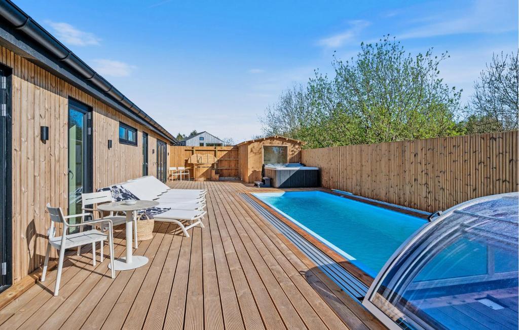 a deck with a table and chairs next to a swimming pool at Beautiful Home In Ejstrupholm in Krejbjerg
