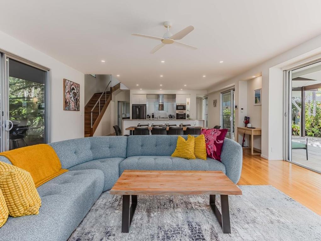 a living room with a blue couch and a table at Macadamia Ocean Escape in Pottsville