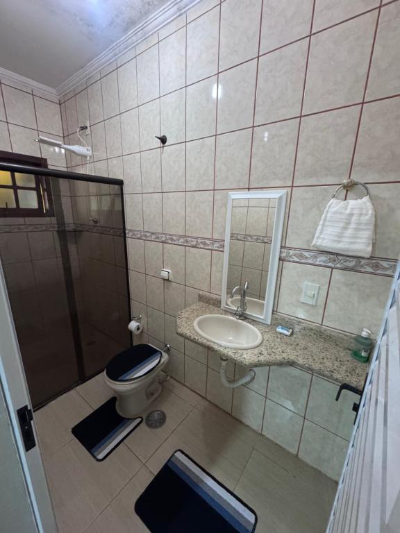 a bathroom with a toilet and a sink and a mirror at Quarto privativo com suite para 1 pessoa in Campinas