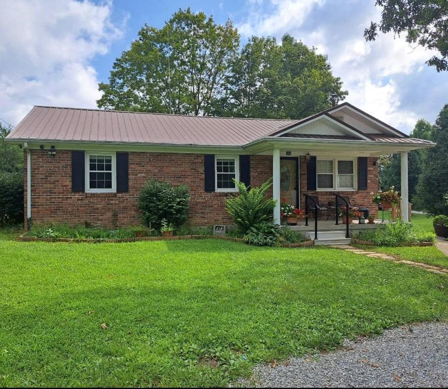 a brick house with a metal roof on a yard at Bourbon Roost in Saint Francis