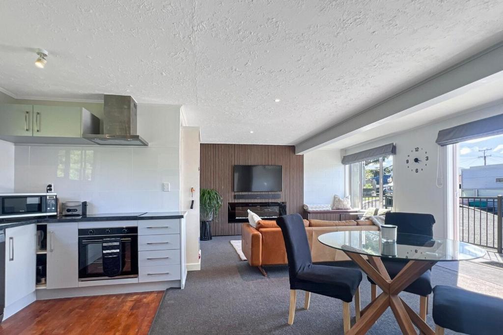 a kitchen and living room with a table and a couch at Selwyn Heights in Akaroa