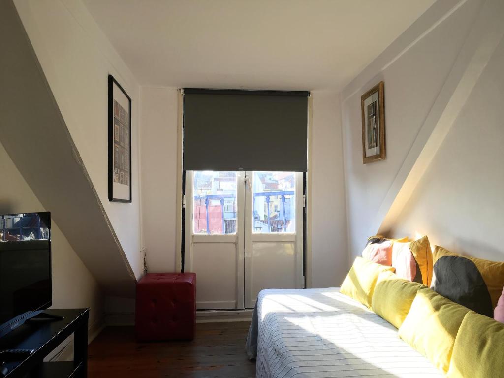 a room with a bed and a sliding glass door at Casa de Cima in Lisbon
