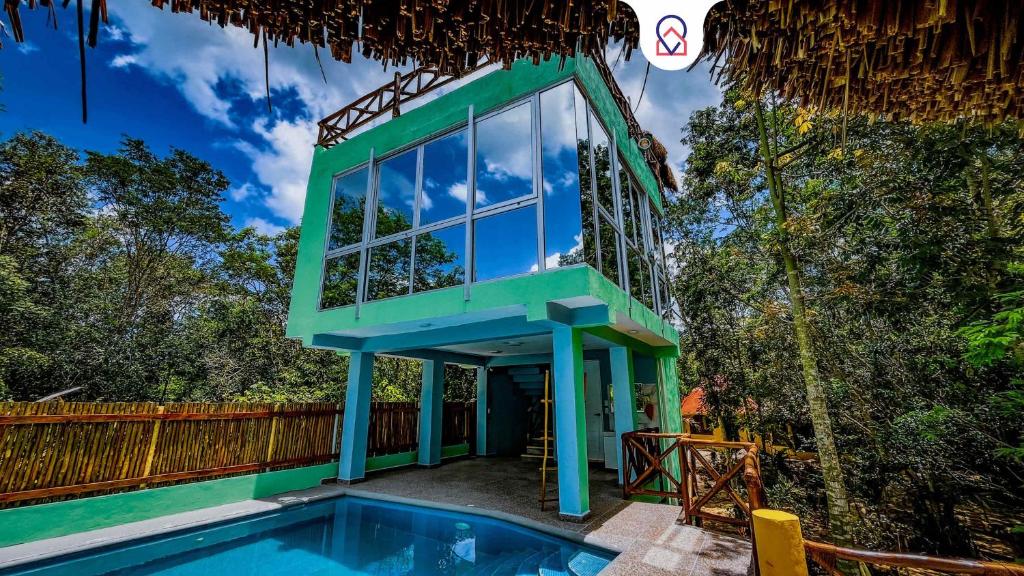 a house with a swimming pool and a blue building at Kaan Serenity Sanctuary in Coba