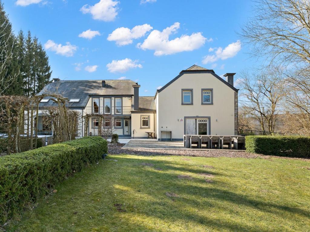 an exterior view of a house with a yard at Luxury Country House with Pool in Manhay