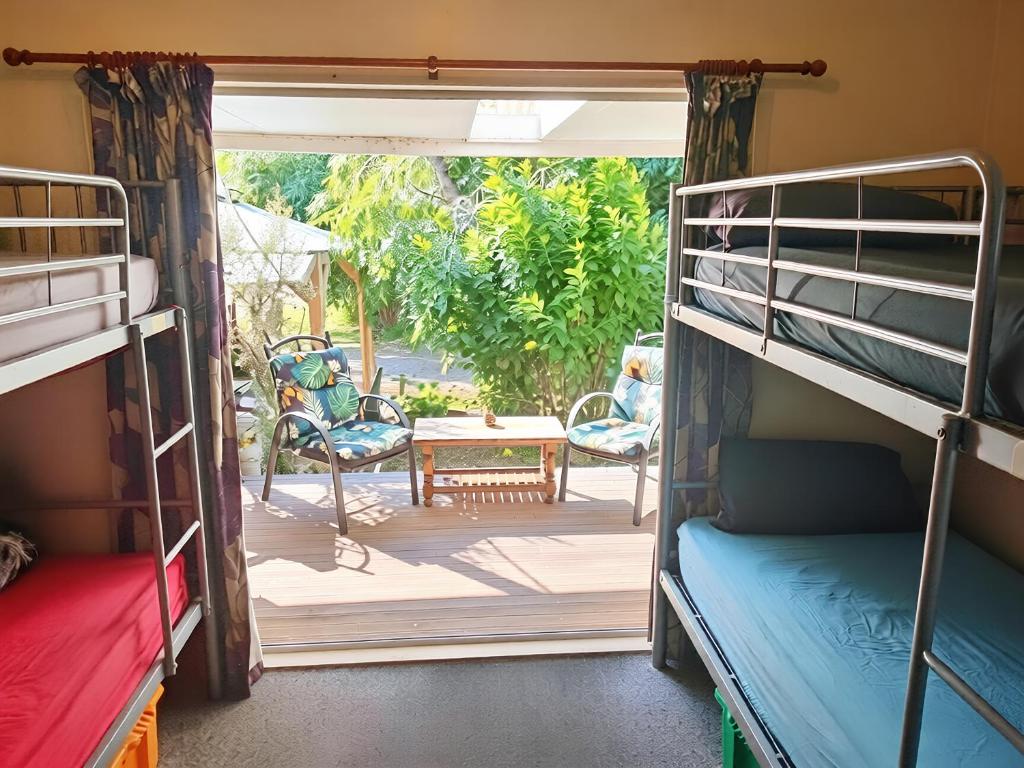 a room with two bunk beds and a patio at Eco Lodge Pakowhai in Hastings