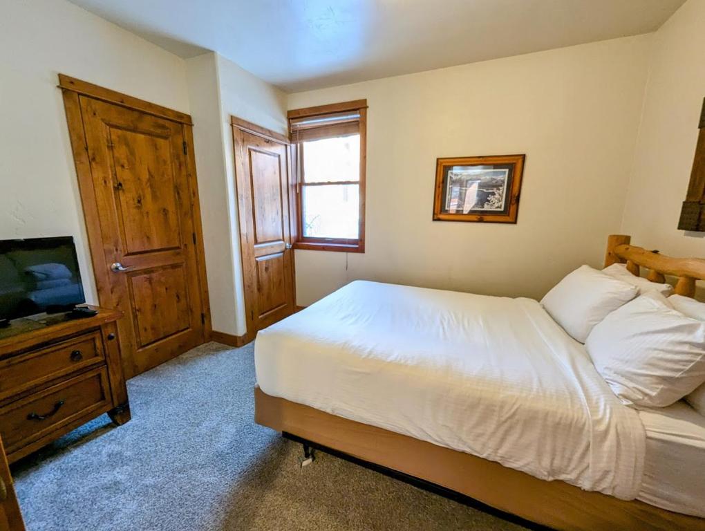 a bedroom with a bed and a flat screen tv at Antlers Gulch 501 by SummitCove Lodging in Colorado in Keystone