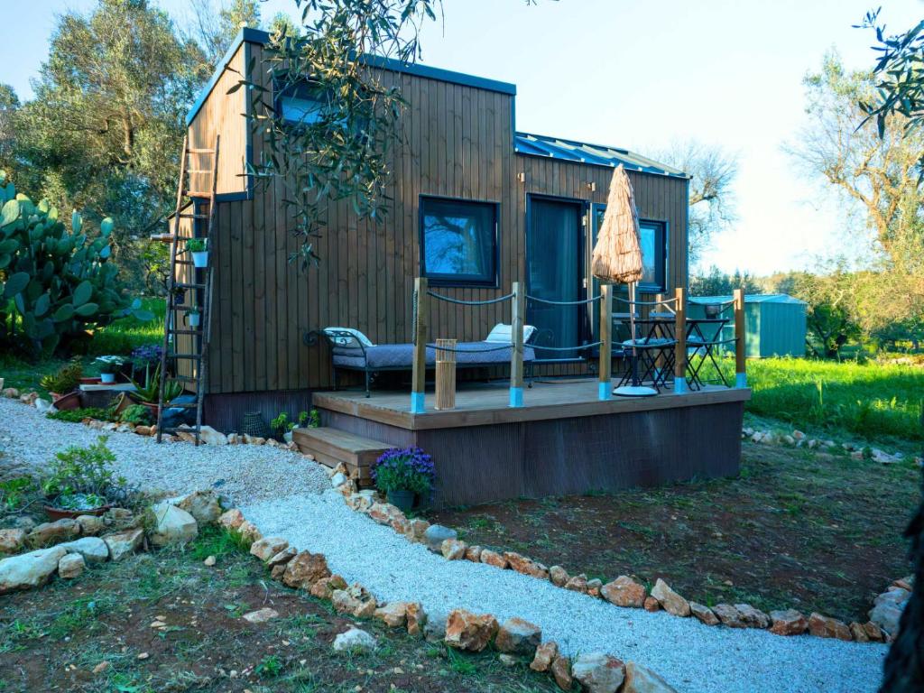 a tiny house with a porch and an umbrella at Il Nostro Sogno - Madonna by Tiny Away in San Michele Salentino