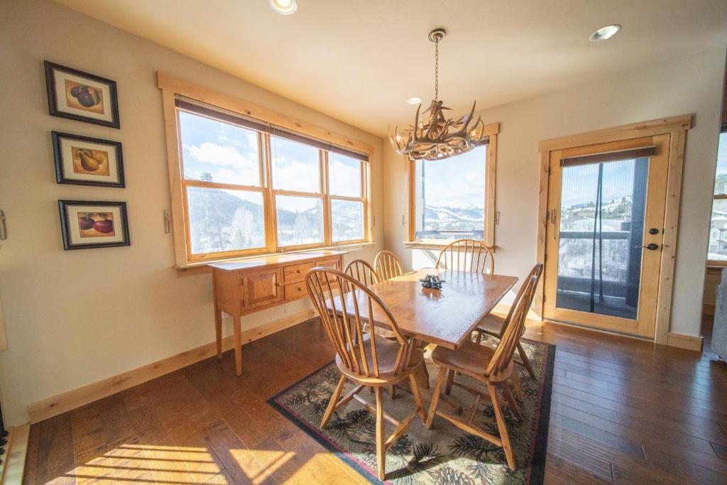 a dining room with a table and chairs and windows at Frey Gulch 46 by SummitCove Lodging in Colorado in Keystone