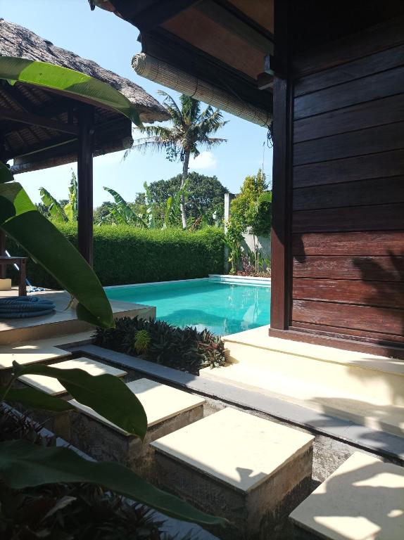 a swimming pool next to a house at Sri Abi Ratu Villa in Sukawati
