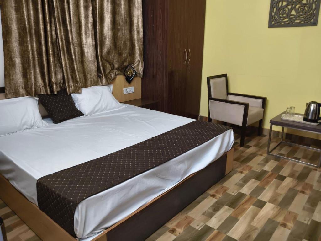 a bedroom with a bed and a chair and a table at Mohdev Resort in Lakhwār