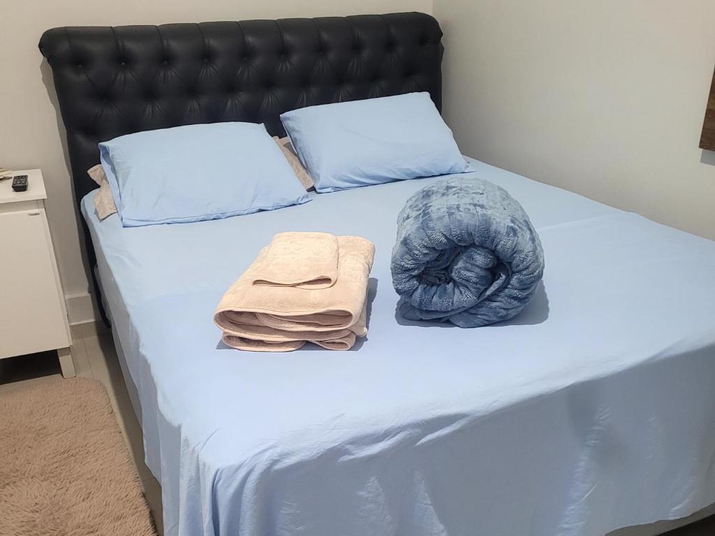 a bed with blue sheets and two towels on it at Apartamento in União da Vitória