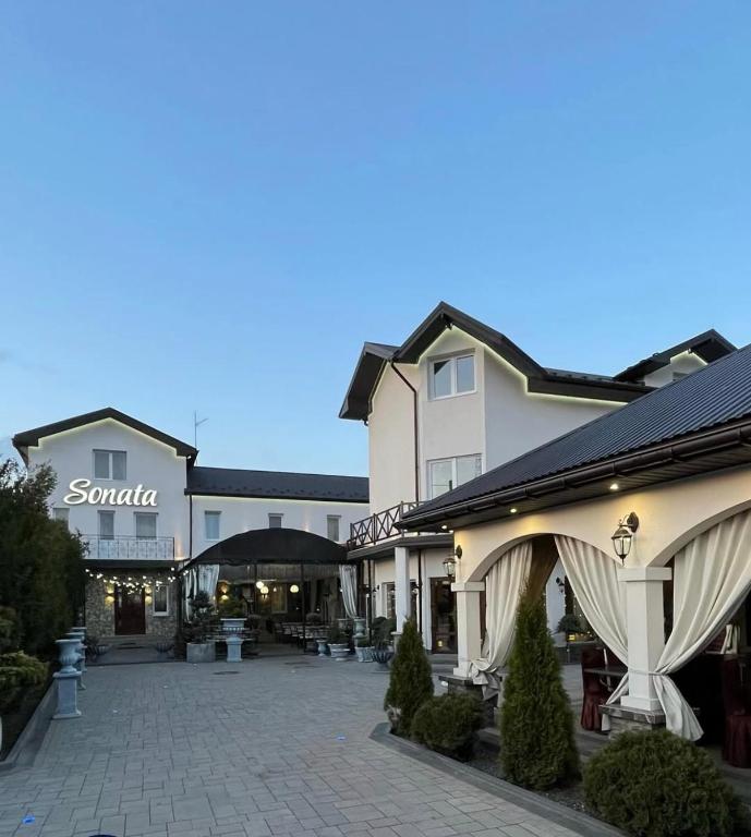 a large building with a courtyard in front of it at Готель-Ресторан Соната in Sambir