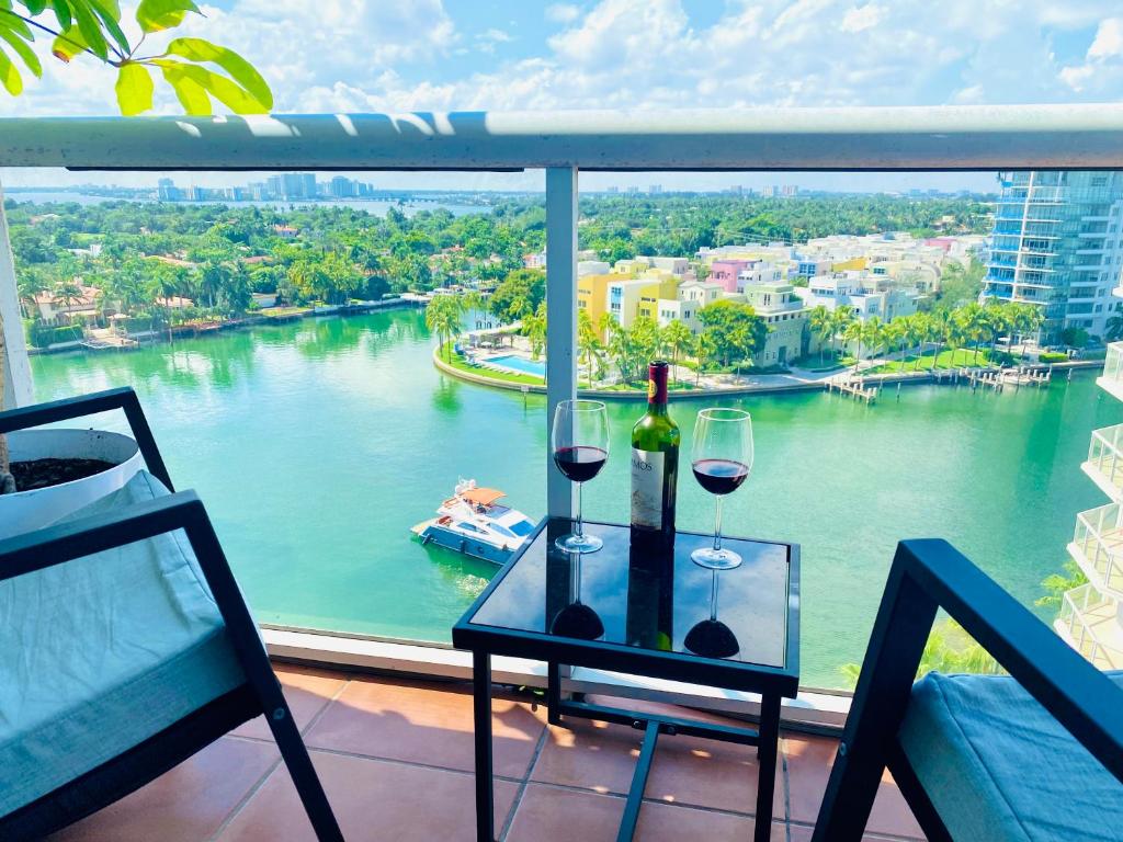 a table with two glasses of wine on a balcony at Ocean & Bay Views 2BR 2BA Beach Condo! Parking in Miami Beach