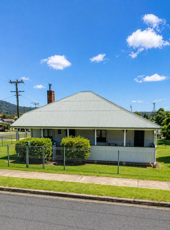 a white house with a fence in front of it at Dillons Cottage in Stanthorpe