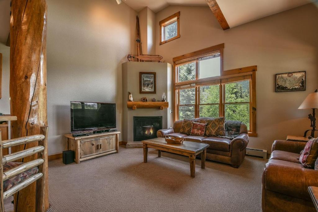 a living room with a couch and a tv at Trappers Crossing 8753 by SummitCove Lodging in Colorado in Keystone