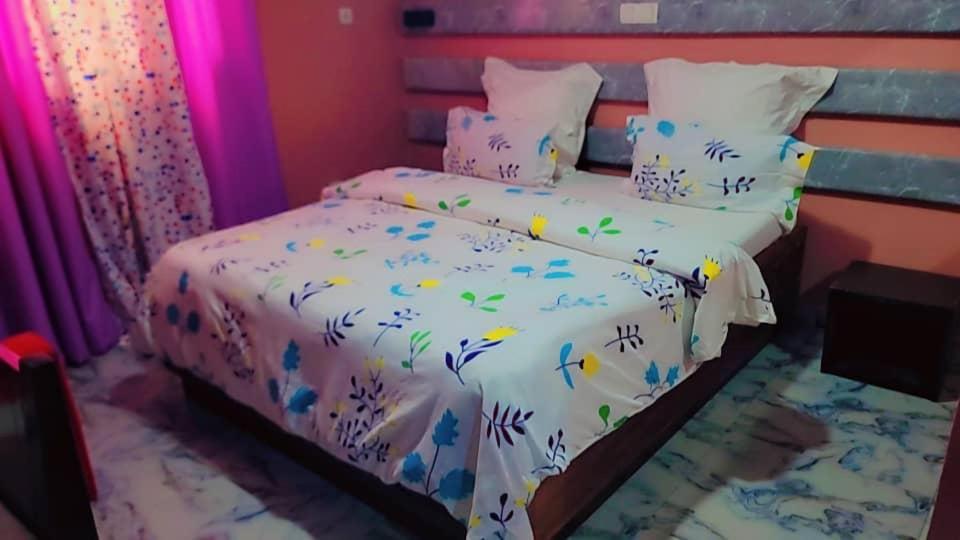 a bedroom with a bed with a white comforter at Sunrise Lodging in Douala