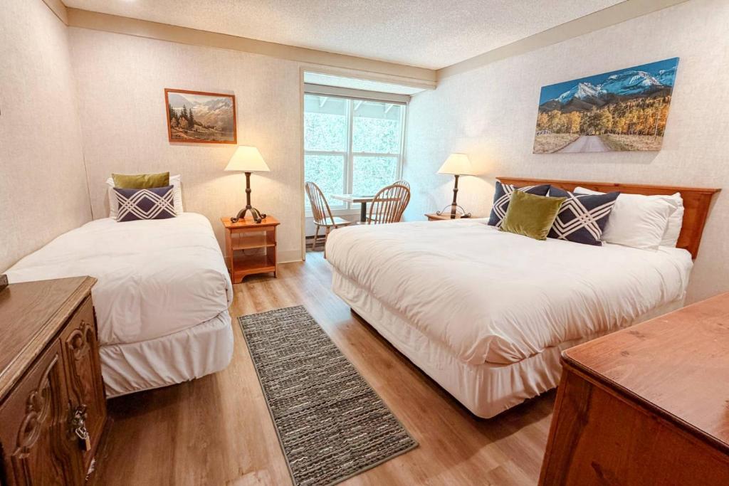 a bedroom with two beds and a table at So Davis St 333 Unit #414 ~ Mountaineer in Telluride
