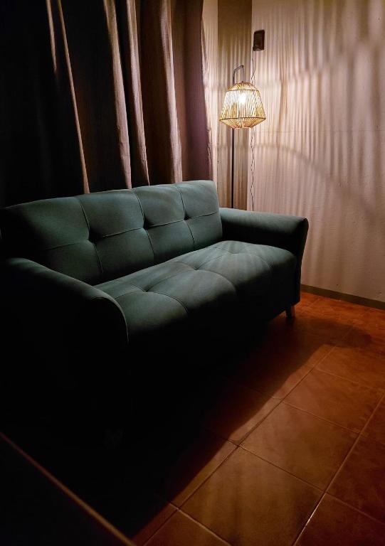 a green couch in a living room with a lamp at Hospedaje El Rancho in Castillos