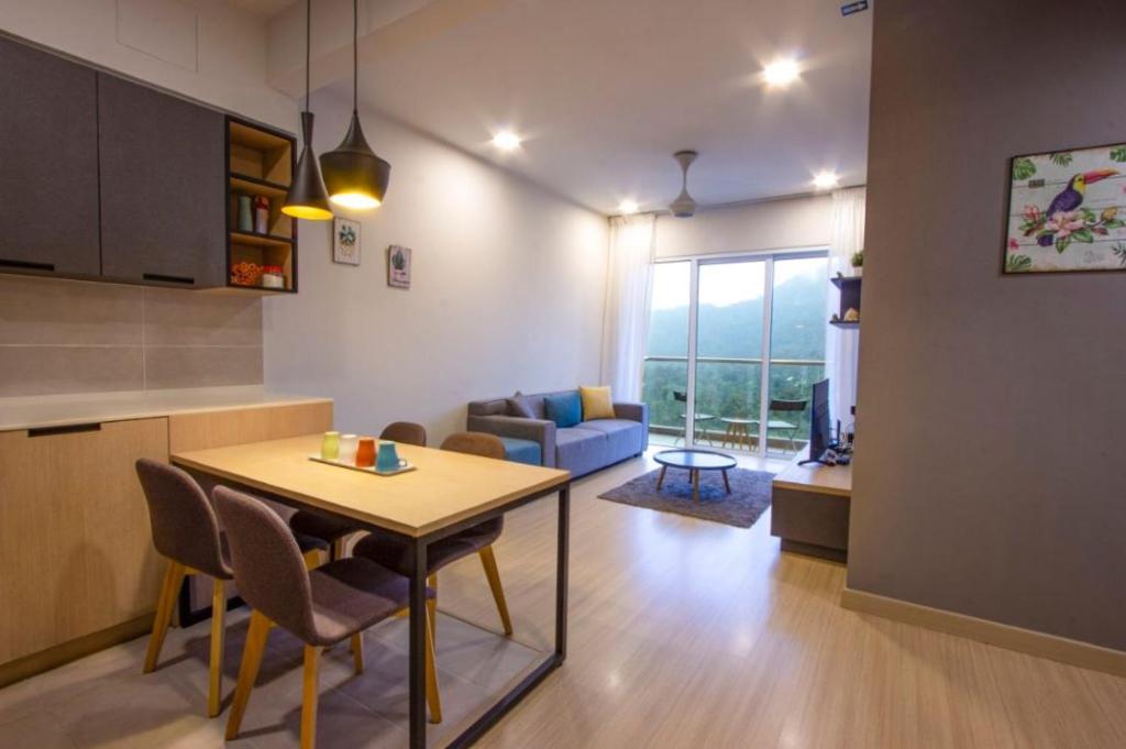 a kitchen and living room with a table and a couch at Genting Premium Suite Windmill Upon Hills by JAz Home Suites in Genting Highlands