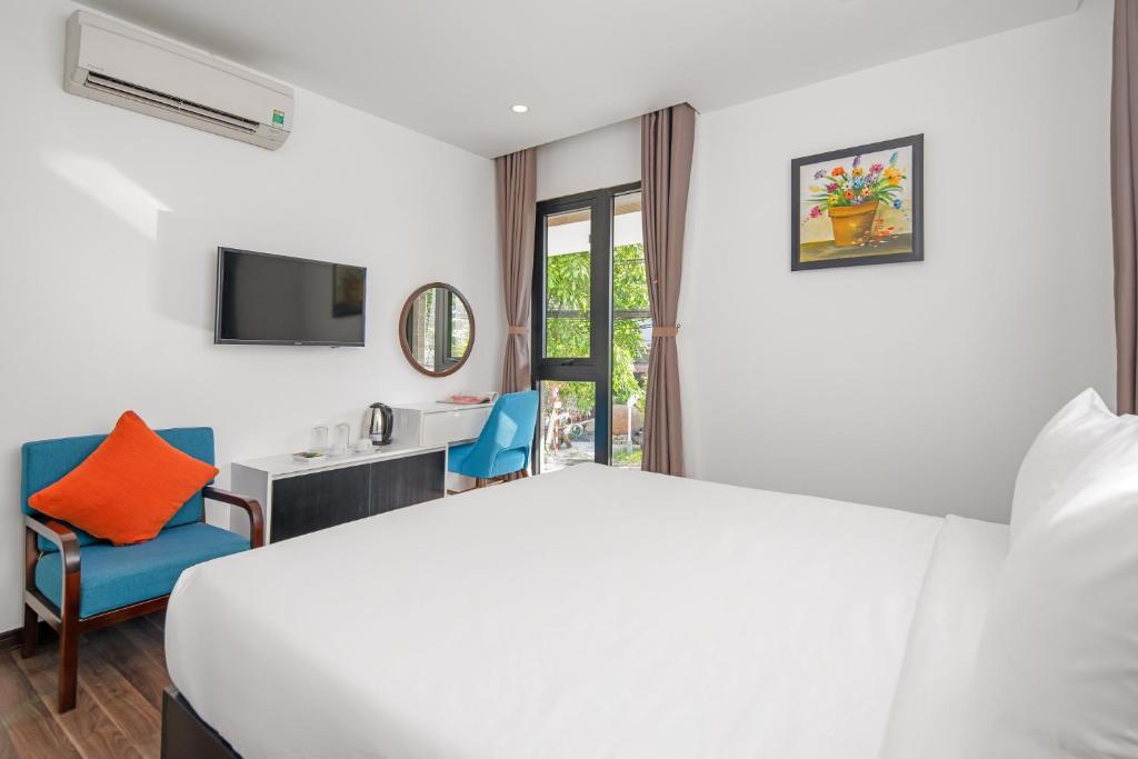 A bedroom with a double bed, small seating area, television and glazed balcony or window door.