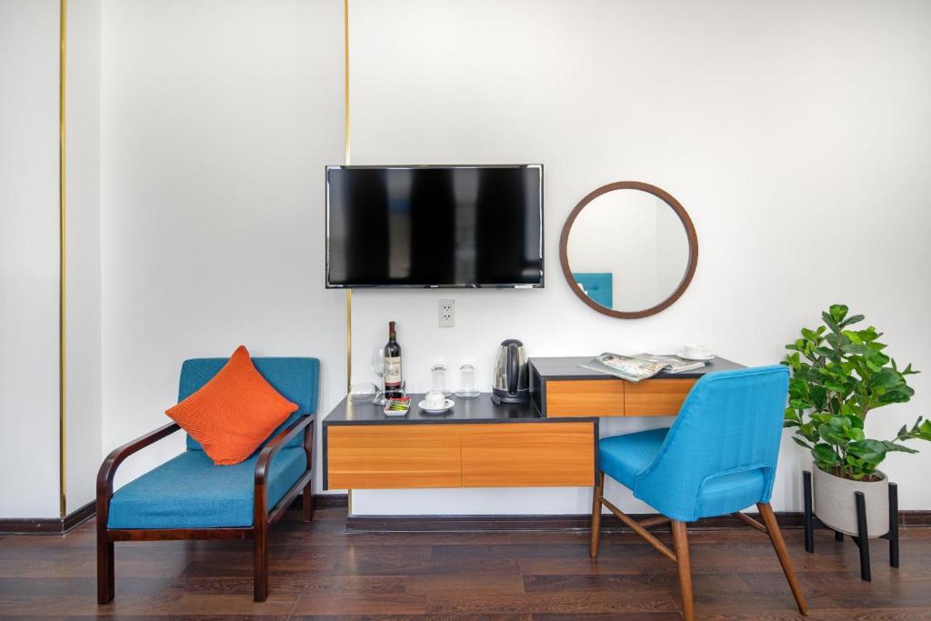A bedroom work and refreshment corner with a desk, chair, television and kettle.
