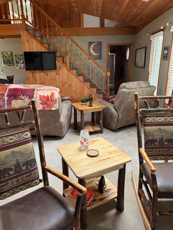 a living room with chairs and a couch and stairs at Woodland Hideaway in Naples