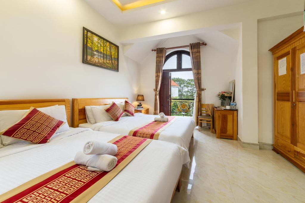 a bedroom with two beds and a window at Xuan Truong Central Dalat-1 min walk to Xuan Huong Lake in Da Lat