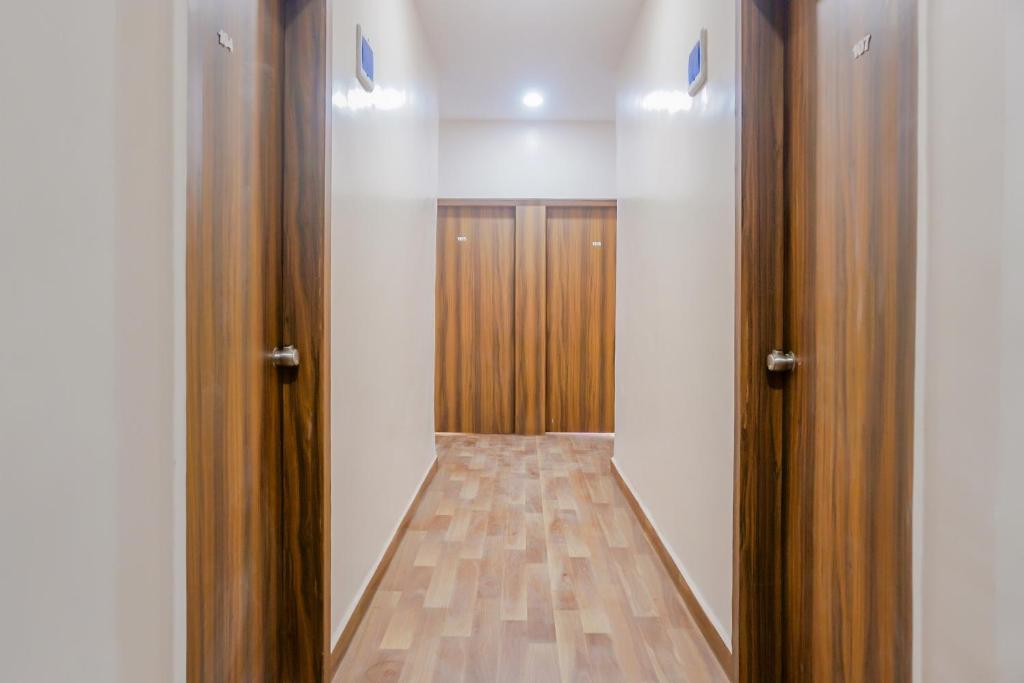 an empty closet with wooden doors in a room at Hotel O Rest Inn in Yeraoda