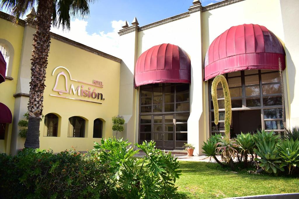 a building with pink domes on the side of it at Hotel Misión Comanjilla in Comanjilla
