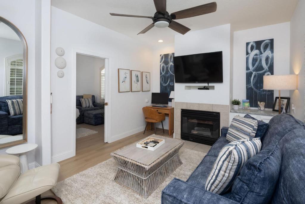 a living room with a blue couch and a fireplace at Luxury At Pier Avenue in Oceano