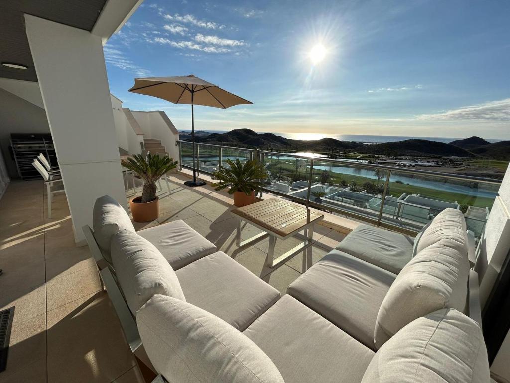 a balcony with white couches and an umbrella at Apartamento cómodo, terraza - 4 pers. - ES-376-48 in Pulpí