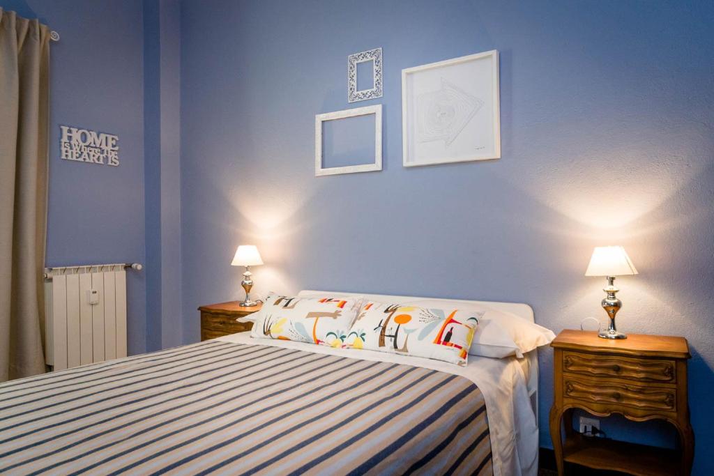 ジェノヴァにあるB&B I Portici Di Sottoripaの青いベッドルーム(ベッド1台、ランプ2つ付)