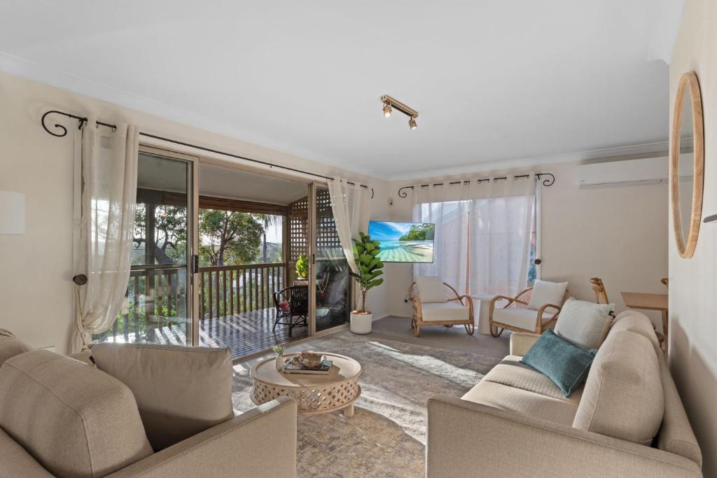 a living room with a couch and a table at Flannel Flower Beach House in Shoal Bay
