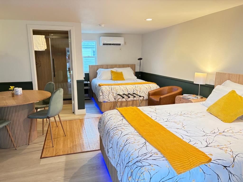a hotel room with two beds and a table at Riverwalk Park Inn in Chelan