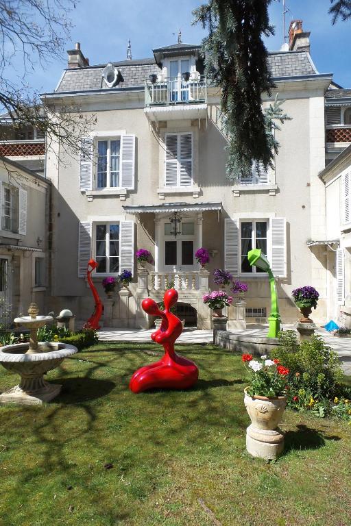a house with some red sculptures in the yard at Le Cedre Bleu in Bourges