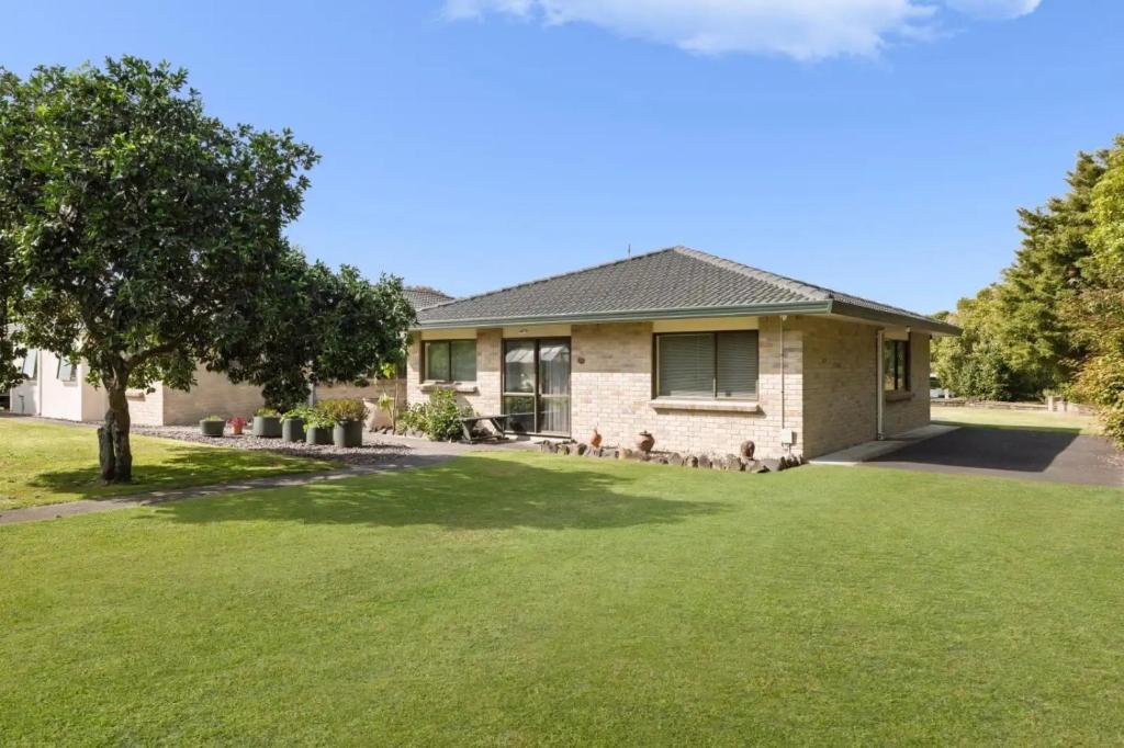 a house with a yard with green grass at The Raukawa Cottage in Tauranga