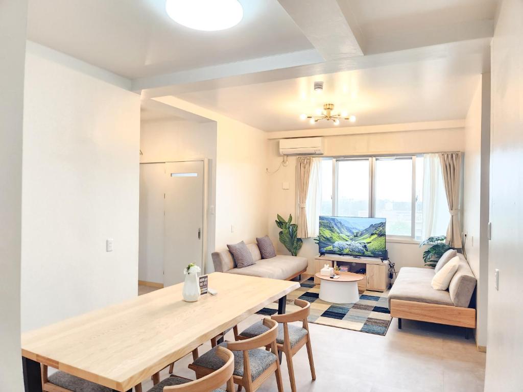 a living room with a table and a couch at seragaki blue twins 201 in Onna